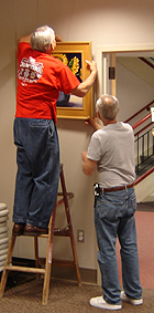 Paul Miller and Tom Mayer hanging the artworks